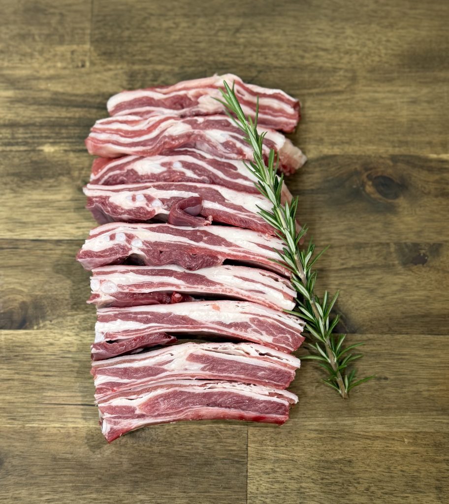 Lamb ribs on board with rosemary herb